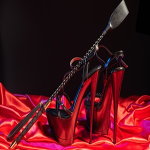 Eine Domina verlangt die Anbetung ihrer High Heels am Telefon.